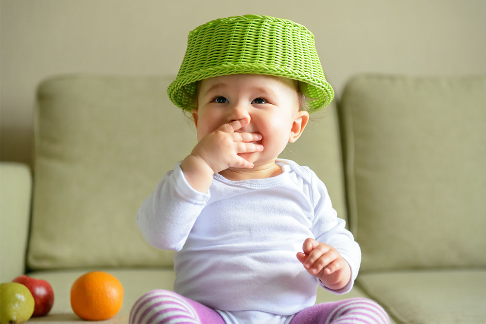 cute baby with fruit basket on head