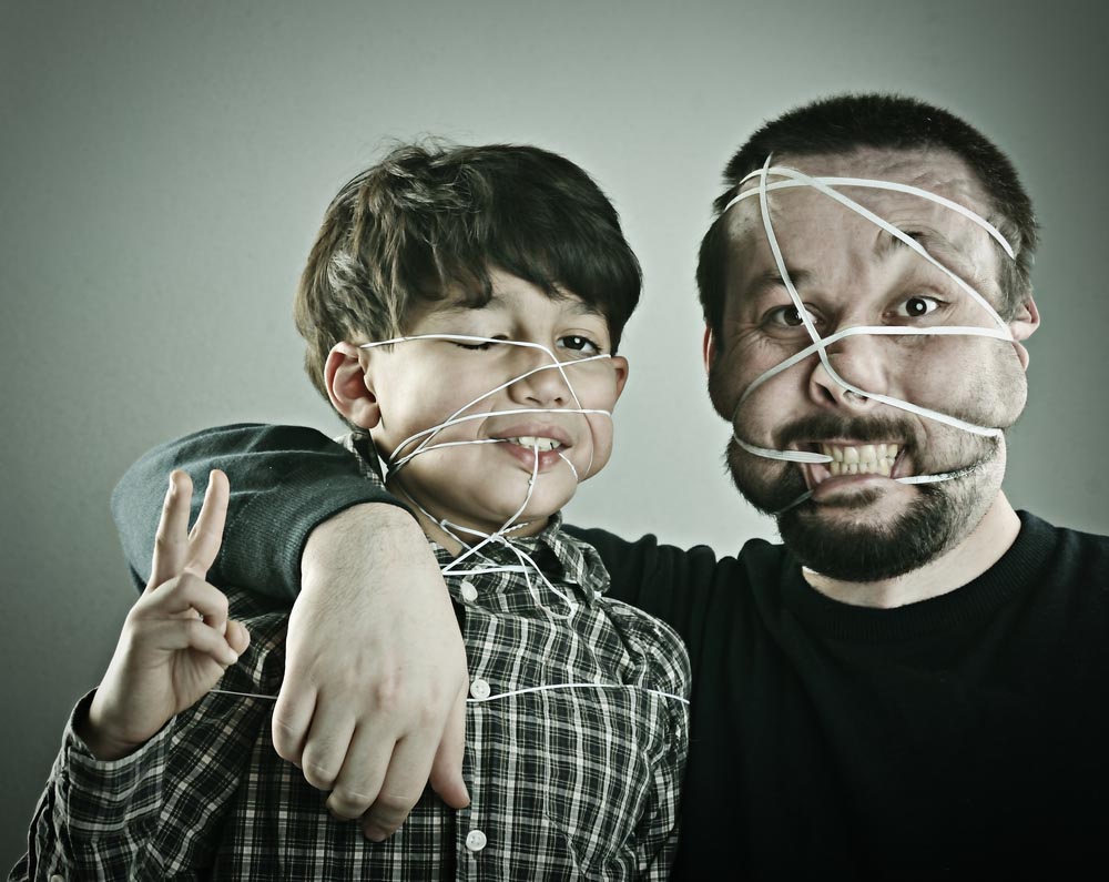 man and son with rubberbands on their faces.