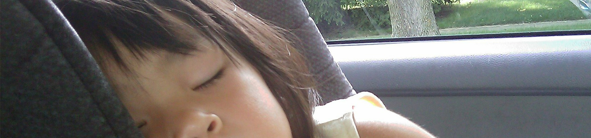 a girl asleep in a car seat
