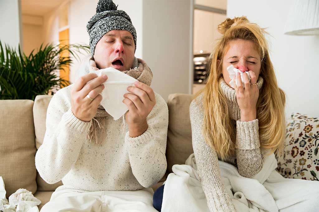 two people sneezing with the cold
