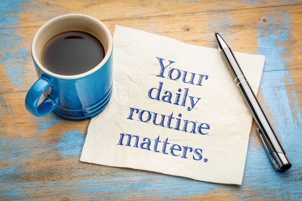 A mug of coffee beside a napkin with the words Your Daily Routine Matters