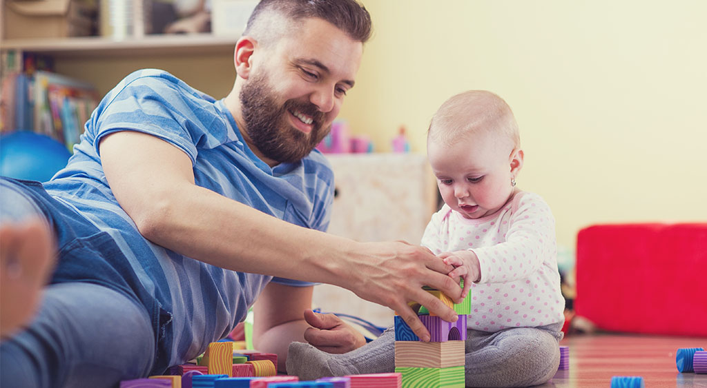 a dad plays with a baby and building bricks