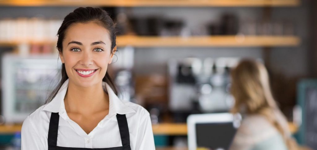A woman working in a cafe, smiling